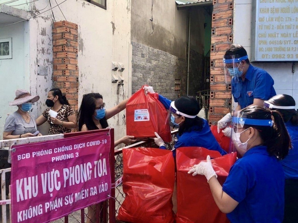 Đoàn viên, thanh niên tình nguyện tại Thành phố Hồ Chí Minh cung cấp nhu yếu phẩm cho những hộ dân thuộc khu vực phong toả tại phường 3, Quận 11. (Ảnh: Hồng Giang/TTXVN)
