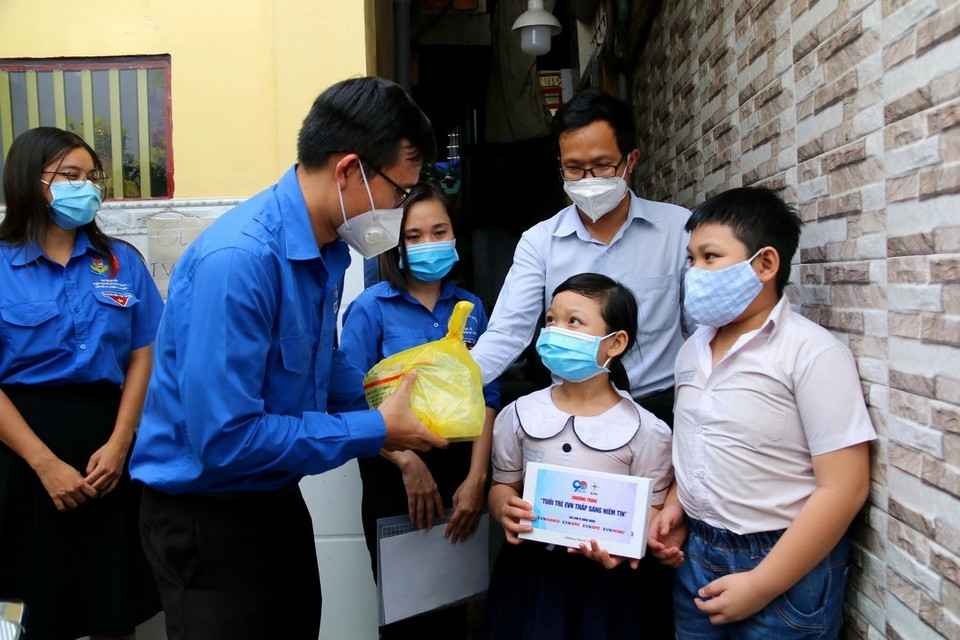 Đoàn thanh niên Tổng Công ty Điện lực Thành phố Hồ Chí Minh và Quận 4 tặng máy tính bảng trong chương trình Tuổi trẻ EVN thắp sáng niềm tin cho trẻ mồ côi do dịch COVID-19 ở Quận 4. (Ảnh: Thanh Vũ/TTXVN)