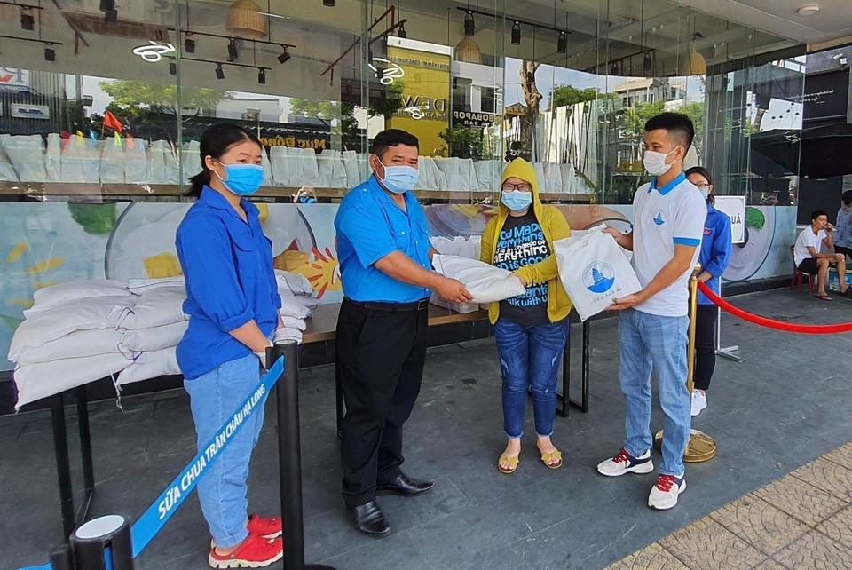 Đại diện Hội Liên hiệp Thanh niên thành phố Đà Nẵng trao nhu yếu phẩm thiết yếu cho người dân gặp khó khăn do ảnh hưởng bởi dịch bệnh COVID-19. (Ảnh: Văn Dũng/TTXVN)