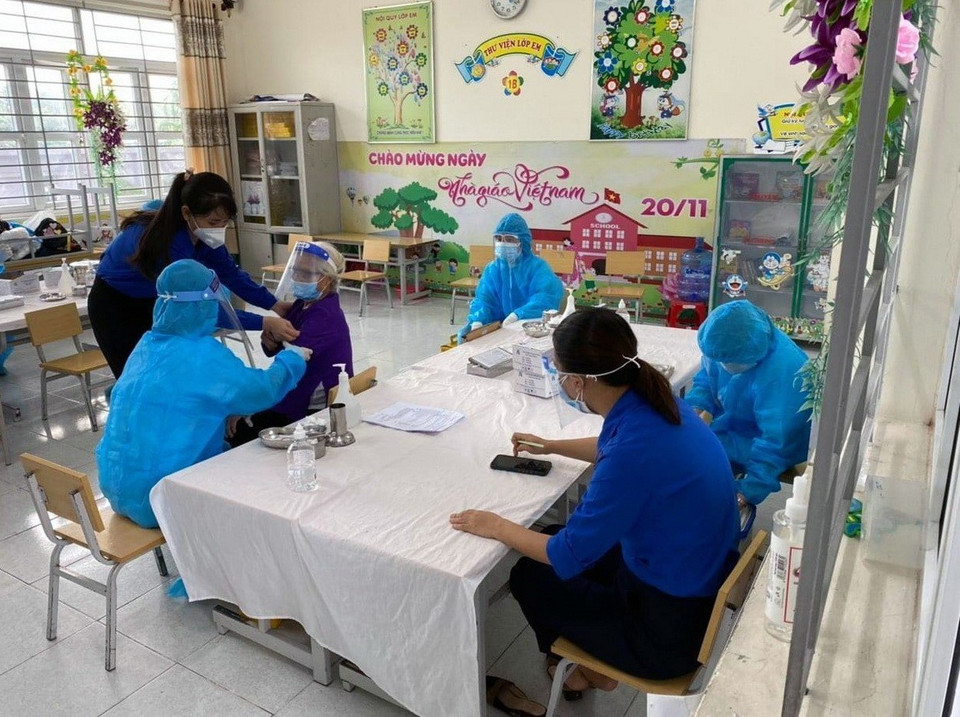 Đoàn viên, thanh niên phường Lương Khánh Thiện (Hà Nam) hỗ trợ lực lượng chức năng tại điểm tiêm vaccine trường trung học cơ sở Lương Khánh Thiện. (Ảnh: Đại Nghĩa/TTXVN)