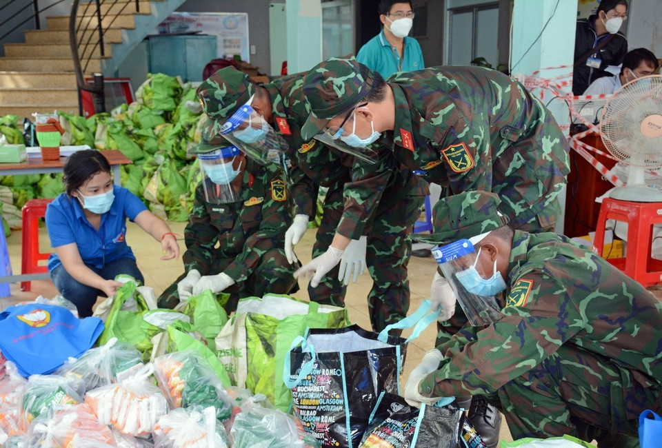 Thanh niên tình nguyện Thành phố Hồ Chí Minh cùng cán bộ, chiến sỹ Trung đoàn 31, Sư đoàn 309 (Quân đoàn 4) chuyển quà cho nhân dân vùng dịch ở phường 16, Quận 8, Thành phố Hồ Chí Minh. (Ảnh: Thanh Vũ/TTXVN)