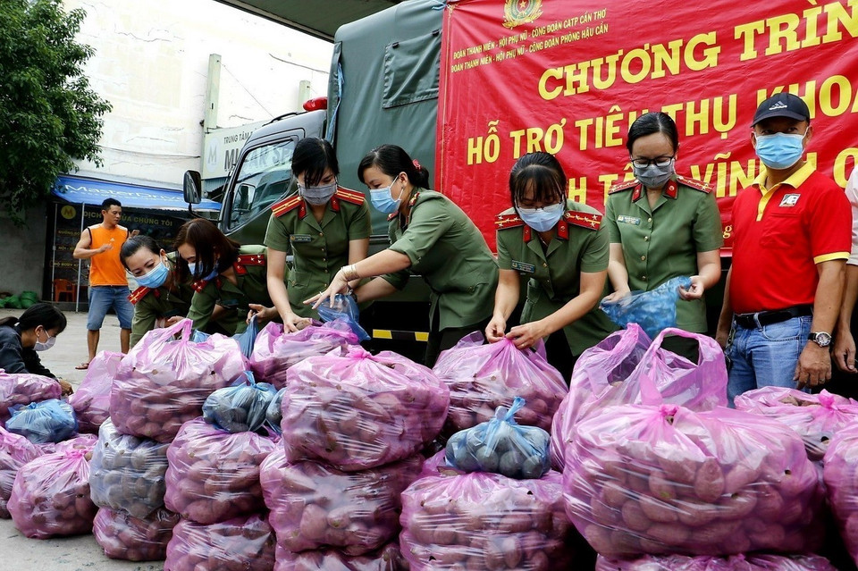 Đoàn viên công an thành phố Cần Thơ hỗ trợ tiêu thụ nông sản cho người dân trong những ngày thành phố bùng phát dịch COVID-19. (Ảnh: Thu Hiền/TTXVN)
