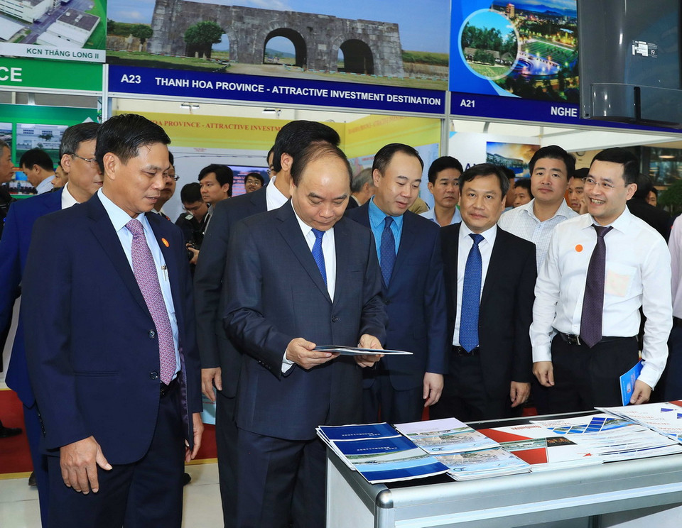 Thủ tướng Nguyễn Xuân Phúc thăm các gian hàng trưng bày tại hội nghị. (Ảnh: Thống Nhất/TTXVN)