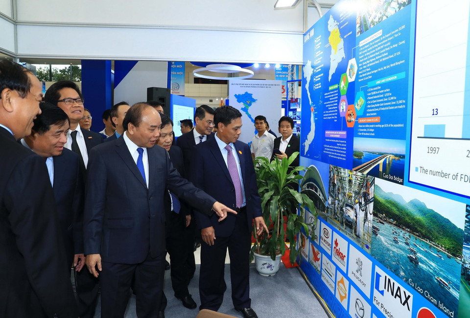 Thủ tướng Nguyễn Xuân Phúc thăm các gian hàng trưng bày tại hội nghị. (Ảnh: Thống Nhất/TTXVN)