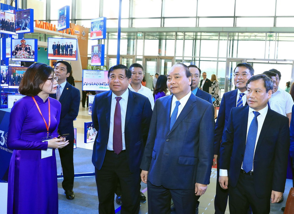 Thủ tướng Nguyễn Xuân Phúc thăm các gian hàng trưng bày tại hội nghị. (Ảnh: Thống Nhất/TTXVN)