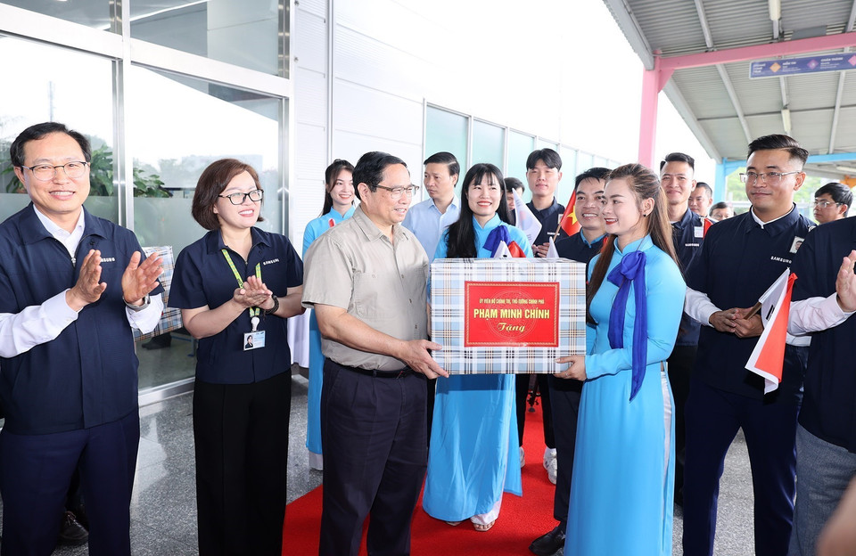 Thủ tướng Phạm Minh Chính tặng quà cho đại diện lãnh đạo, nhân viên Công ty TNHH Samsung Việt Nam. (Ảnh: Dương Giang/TTXVN)