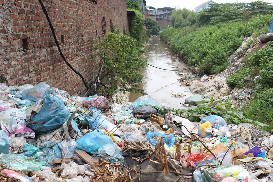 Rác thải vứt thành từng đống quanh các con mương dẫn nước thải đổ ra sông. (Ảnh: Hùng Võ/Vietnam+)