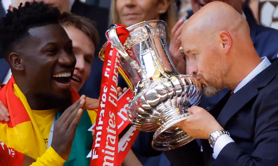 HLV Erik ten Hag hôn chiếc cúp vô địch FA Cup. (Nguồn: Guardian)
