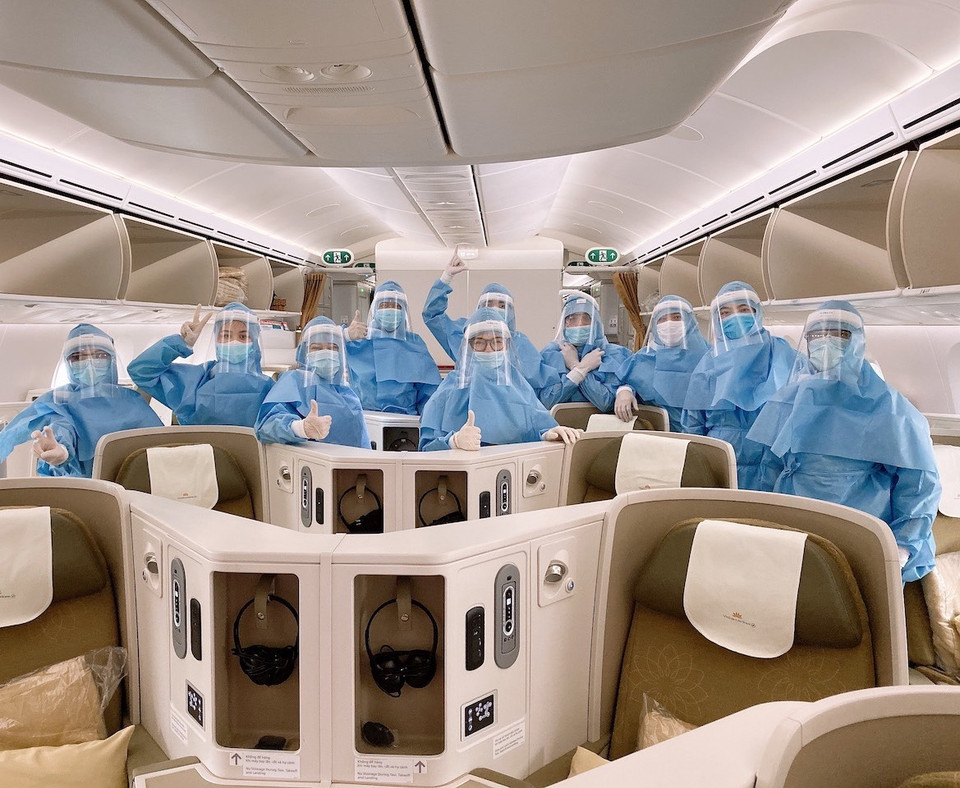 Các phi công, tiếp viên mặc trang phục bảo hộ trước khi thực hiện chuyến bay. (Ảnh: VNA cung cấp)