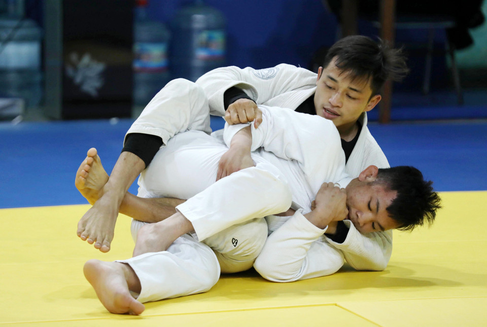 Vận động viên Nguyễn Hữu Khang (hạng 69kg, phía trên) tập luyện cùng vận động viên Đào Hồng Sơn (hạng dưới 56kg). (Ảnh: Hoàng Hiếu/TTXVN)