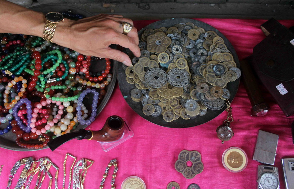 Những đồng tiền xu thời xưa, những chiếc vòng cổ bằng vàng, bạc được bày bán ngay tại gian hàng dựng tạm. (Ảnh: Thanh Hoa/TTXVN)