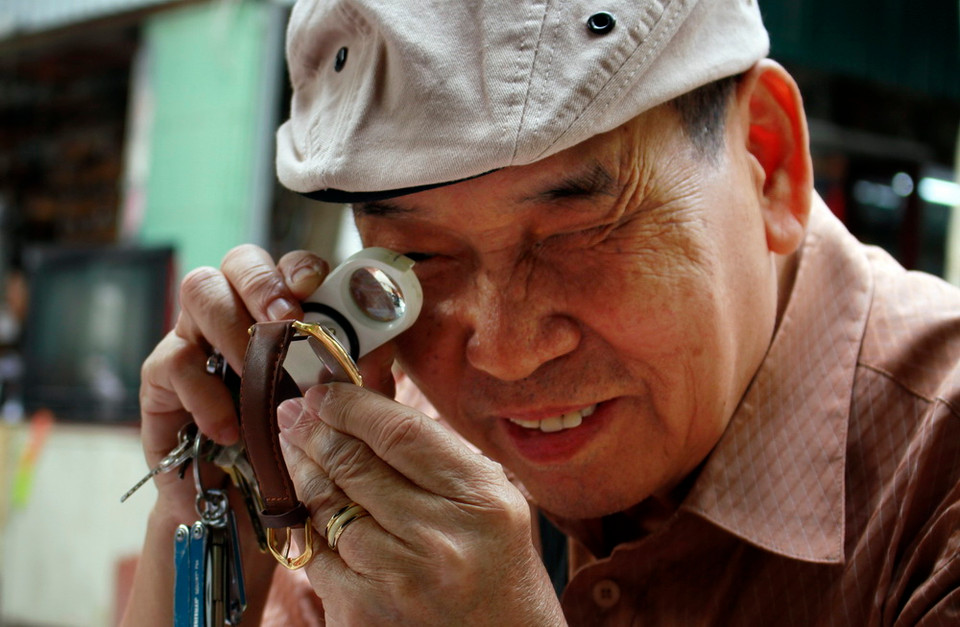 Khách hàng kiểm tra chất lượng đồng hồ cổ tại Chợ đồ cũ Vạn Phúc. (Ảnh: Thanh Hoa/TTXVN)