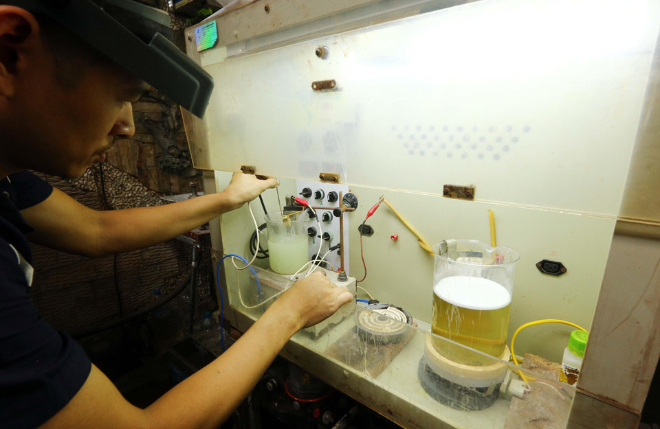 Công đoạn làm bóng sản phẩm nhẫn bằng hóa chất. (Ảnh: Trần Việt/TTXVN)