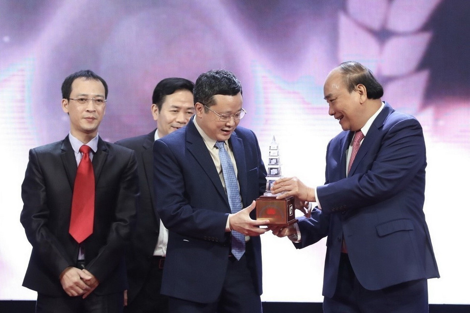 Chủ tịch nước Nguyễn Xuân Phúc và Thường trực Ban Bí thư Võ Văn Thưởng trao giải Đặc biệt cho nhóm tác giả thuộc báo Nhân dân tại Lễ trao Giải báo chí quốc gia lần thứ XV - năm 2020. (Ảnh: Minh Quyết/TTXVN)