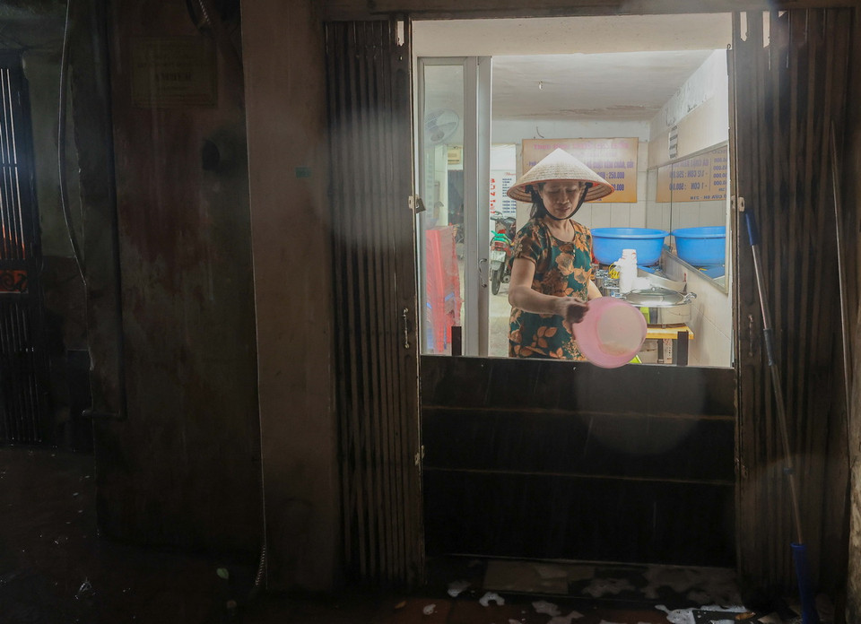 Một nhà dân tại ngõ 39 phố Quang Trung dù đã che chắn nhưng vẫn phải tát do bị ngập nước. (Ảnh: Hoàng Hiếu/TTXVN)