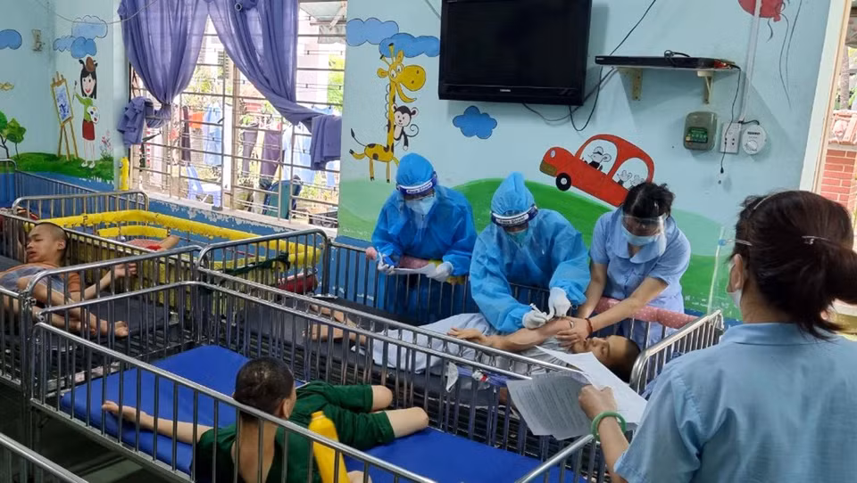 Các y bác sỹ lực lượng tăng cường của Bộ Lao động, Thương binh và Xã hội tiêm vaccine phòng COVID-19 cho người khuyết tật tại Trung tâm Bảo trợ trẻ tàn tật mồ côi Thị Nghè, thành phố Hồ Chí Minh. (Ảnh: Thanh Vũ/TTXVN)