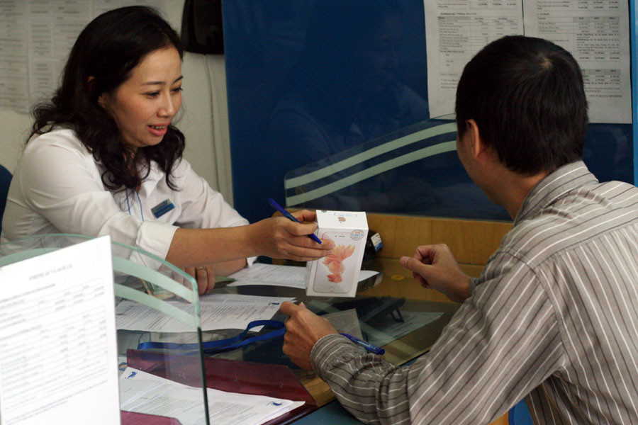 Nhân viên cửa hàng VinaPhone giao máy cho khách hàng. (Ảnh: Trung Hiền/Vietnam+)