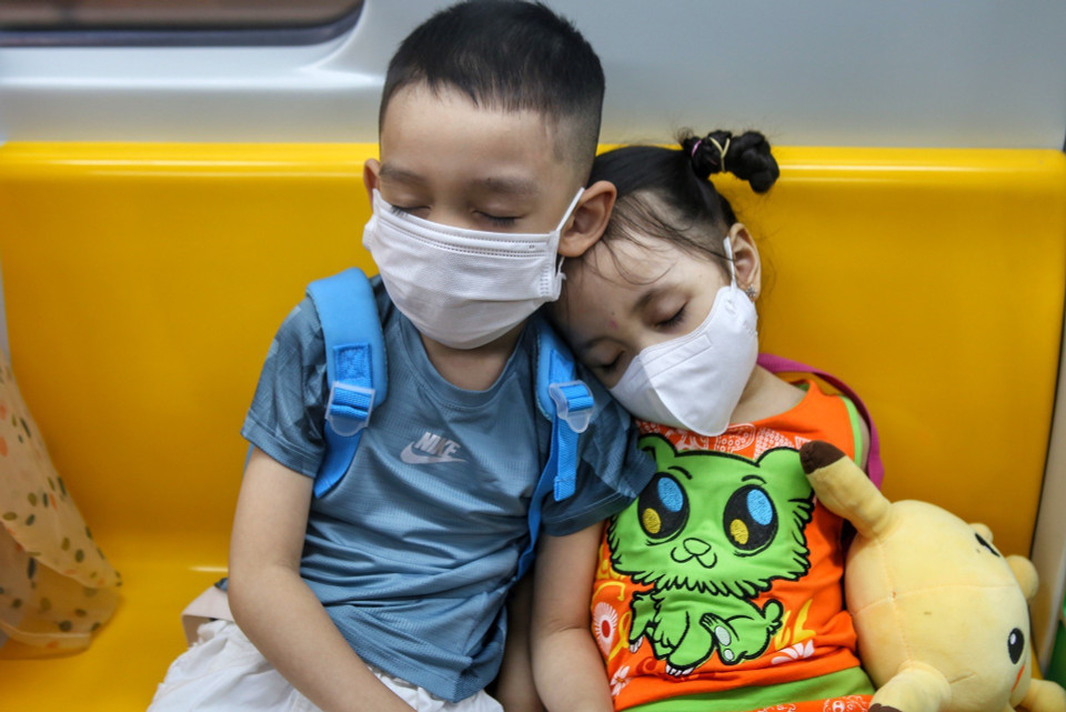 Hai em nhỏ ngủ trên toa trong chuyến hành trình. (Ảnh: Tuấn Đức/TTXVN)