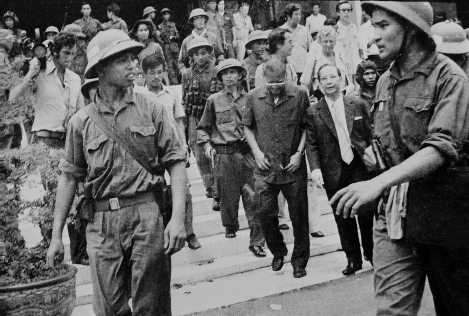 Quân giải phóng dẫn giải Tổng thống Dương Văn Minh và Thủ tướng Vũ Văn Mẫu của Ngụy quyền Sài Gòn tới Đài Phát thanh để đọc lời tuyên bố đầu hàng vô điều kiện, trưa 30/4/1975, đánh dấu thắng lợi trọn vẹn của chiến dịch Hồ Chí Minh lịch sử, đỉnh cao của cuộc Tổng tiến công và nổi dậy mùa Xuân năm 1975, giải phóng hoàn toàn miền Nam, thống nhất đất nước. (Ảnh: TTXVN)