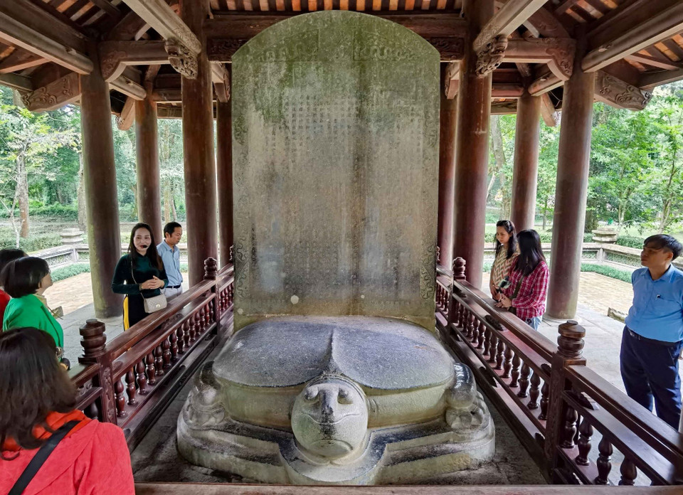 Văn bia nặng gần 18 tấn, gồm hai phần: bia phía trên và rùa phía dưới làm từ đá trầm tích xám xanh lẫn đốm trắng, bề mặt rùa và bia còn nhiều vỏ nhuyễn thể. (Ảnh: Thanh Tùng/TTXVN)