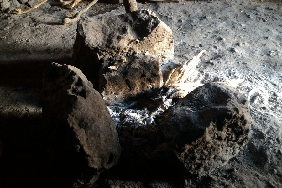 Bếp lửa được kê bằng ba viên đá, mặt không bằng phẳng. (Ảnh: T.H/Vietnam+)