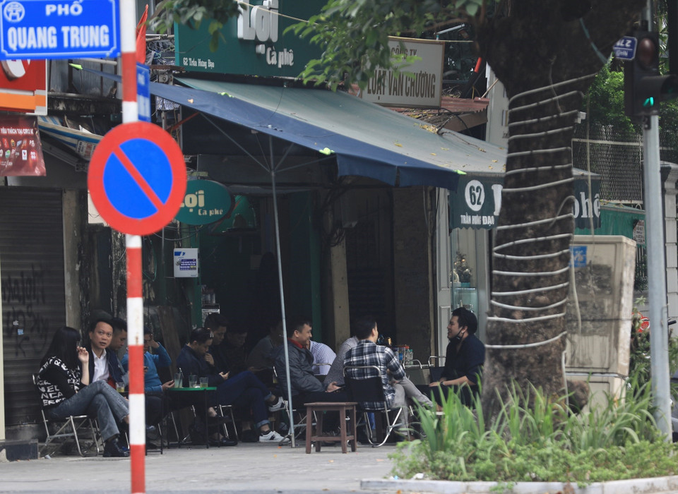 Một quán càphê trên phố Trần Hưng Đạo kinh doanh lấn chiếm vỉa hè, để khách ngồi không đảm bảo khoảng cách phòng dịch. (Ảnh: Hoàng Hiếu/TTXVN)