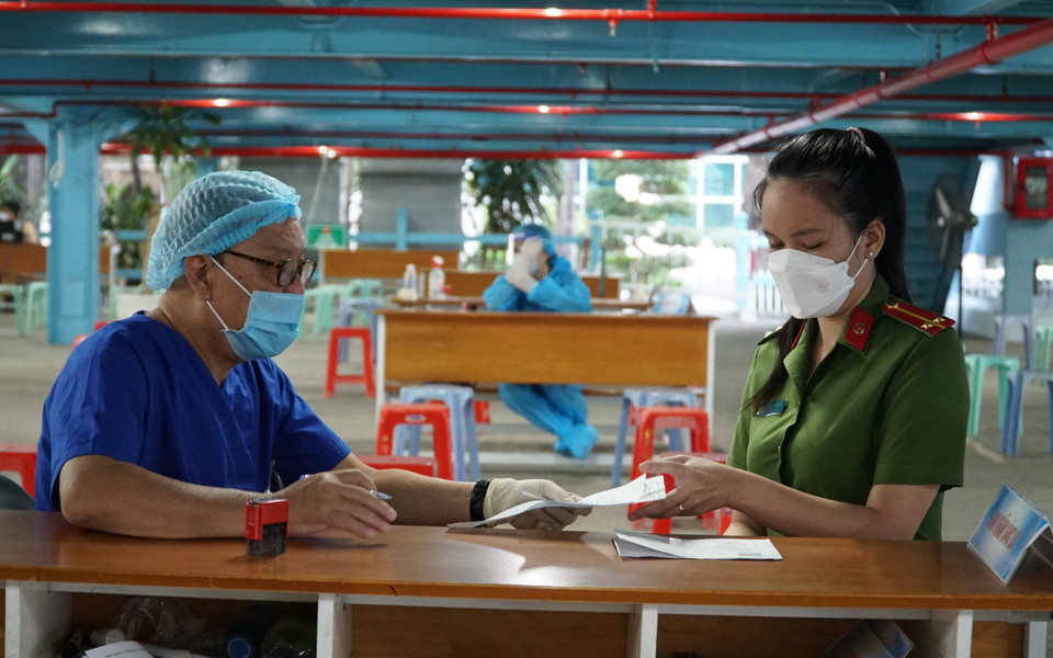 Nhân viên y tế tư vấn cho lực lượng công an trước khi tiêm vaccine. (Ảnh: Thu Hương/TTXVN)