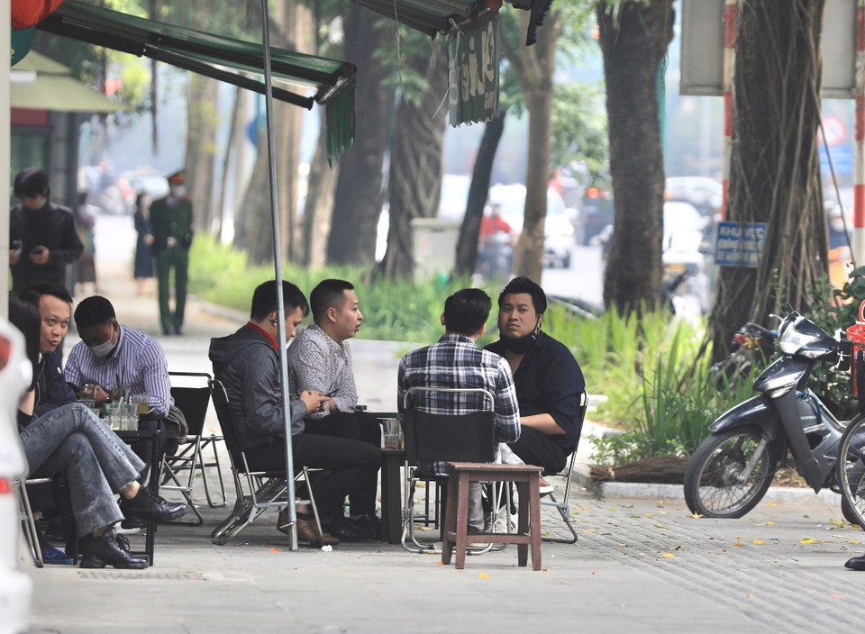 Một quán càphê trên phố Trần Hưng Đạo kinh doanh lấn chiếm vỉa hè, để khách ngồi không đảm bảo khoảng cách phòng dịch. (Ảnh: Hoàng Hiếu/TTXVN)