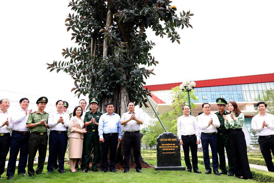 Thủ tướng Phạm Minh Chính và các đại biểu bên Cây đa Hữu nghị do Tổng Bí thư Nguyễn Phú Trọng trồng tại Cửa khẩu Quốc tế Hữu Nghị. (Ảnh: Dương Giang/TTXVN)