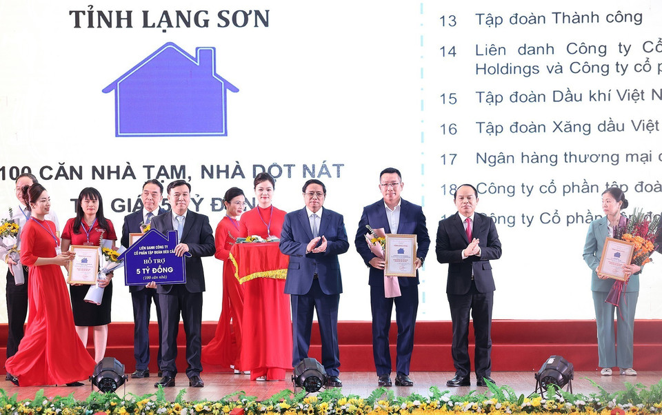 Thủ tướng Phạm Minh Chính và Bí thư Tỉnh ủy Lạng Sơn Nguyễn Quốc Đoàn trao chứng nhận cho các nhà tài trợ chương trình xoá nhà tạm, nhà dột nát trên địa bàn tỉnh Lạng Sơn. (Ảnh: Dương Giang/TTXVN)