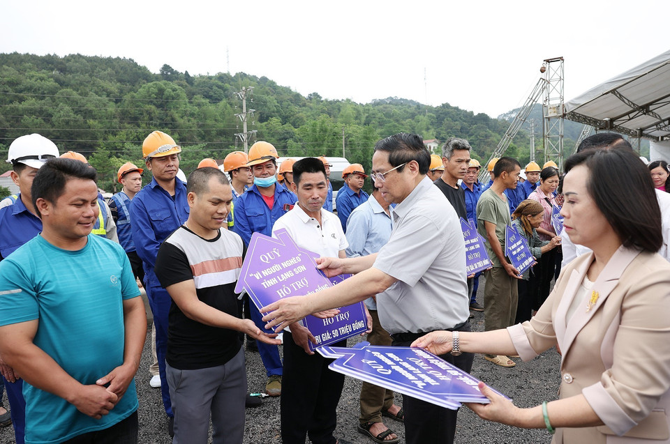 Thủ tướng Phạm Minh Chính trao tặng biểu trưng hỗ trợ xây nhà Đại đoàn kết cho hộ nghèo vùng dự án cải tạo, nâng cấp Quốc lộ 4B, đoạn qua địa bàn tỉnh Lạng Sơn. (Ảnh: Dương Giang/TTXVN)