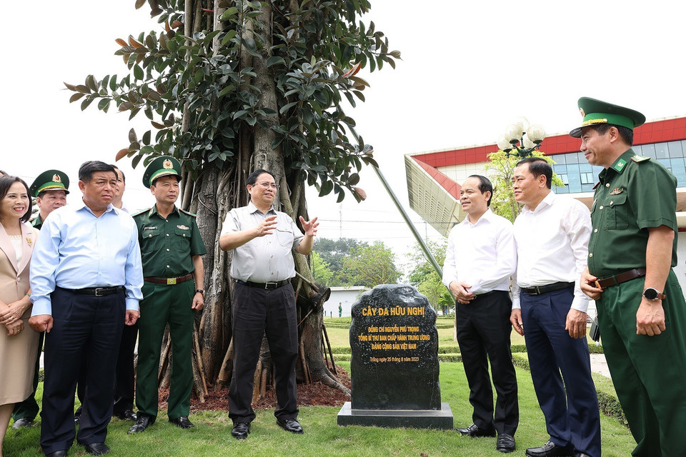 Thủ tướng Phạm Minh Chính và các đại biểu bên Cây đa Hữu nghị do Tổng Bí thư Nguyễn Phú Trọng trồng tại Cửa khẩu Quốc tế Hữu Nghị. (Ảnh: Dương Giang/TTXVN)