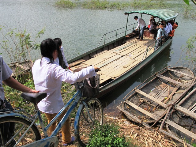 Hàng ngày, các em học sinh phải đến trường trên một phương tiện duy nhất là con đò đã cũ. (Ảnh: Xuân Tùng/Vietnam+)