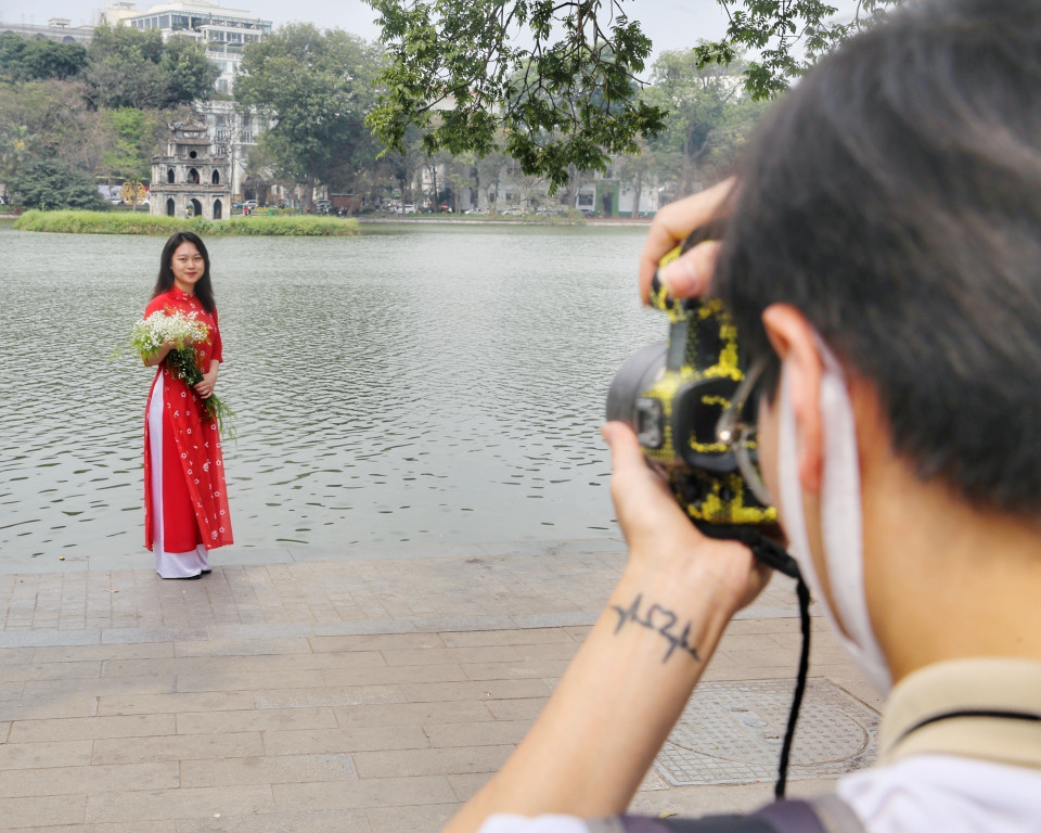 Cánh đàn ông chụp ảnh cho các chị em phụ nữ. (Ảnh: Tuấn Đức/TTXVN)