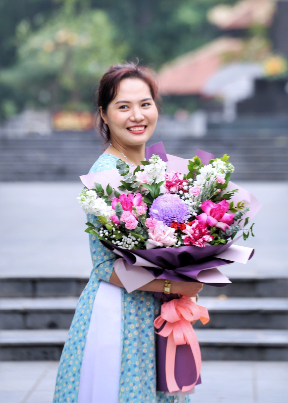 Phụ nữ Thủ đô duyên dáng trong tà áo dài cùng bó hoa rực rỡ màu sắc. (Ảnh: Tuấn Đức/TTXVN)