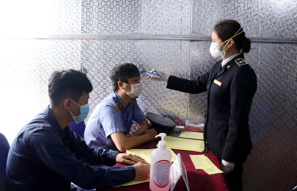 Các nhân viên kiểm tra thân nhiệt trước giờ lên đường làm nhiệm vụ. (Ảnh: Quốc Khánh/TTXVN)