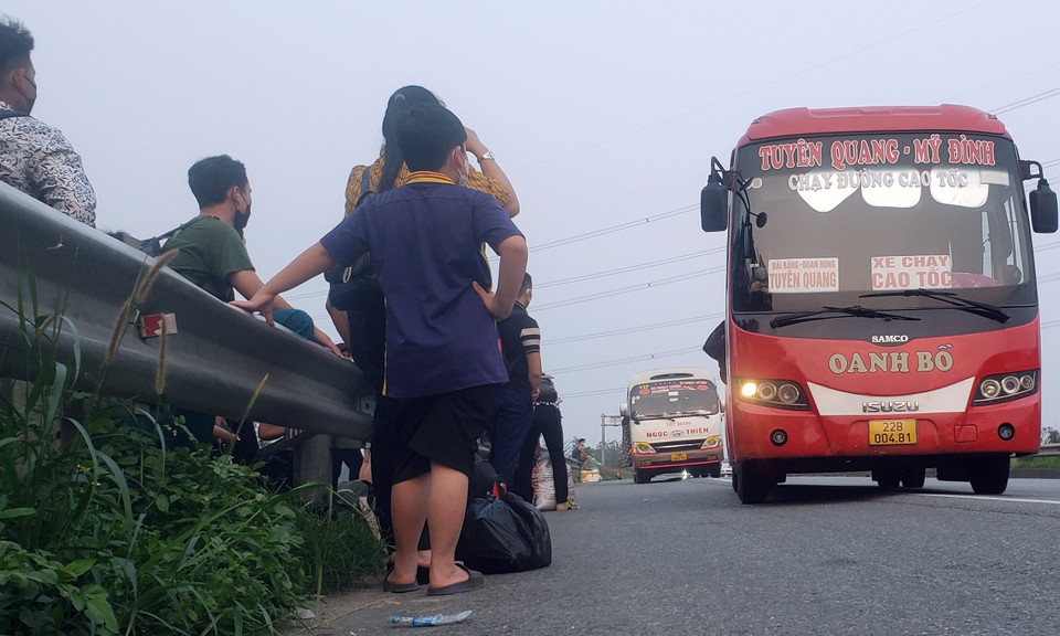 Người dân ngang nhiên vượt qua rào chắn để đón xe cao tốc Nội Bài-Lào Cai tại km26 (gần nút giao IC04 thuộc địa bàn tỉnh Vĩnh Phúc). (Ảnh: Hoàng Hùng/TTXVN)