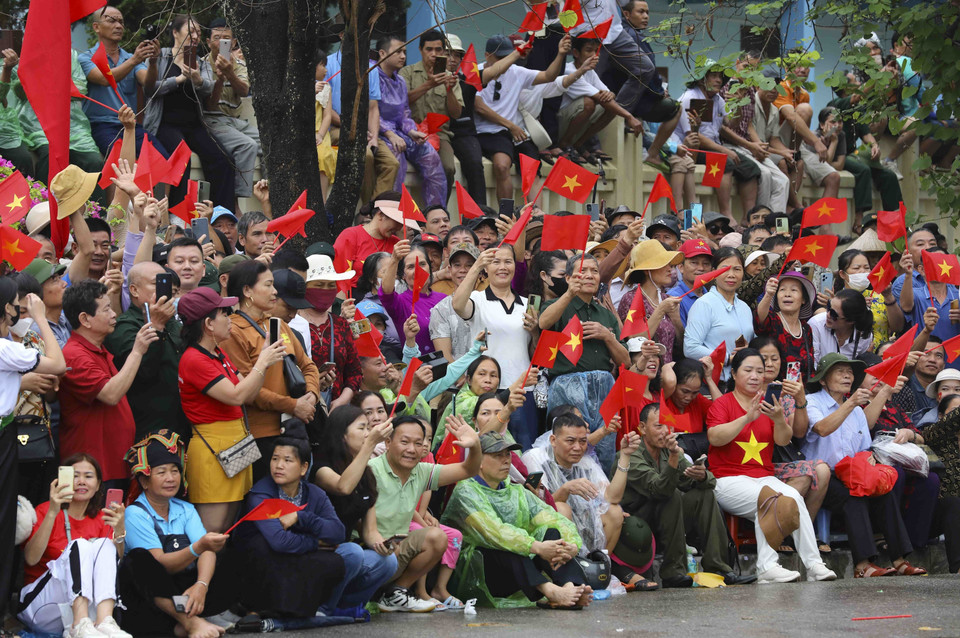 Người dân và du khách có mặt rất sớm để động viên, cổ vũ cho các lực lượng tham gia diễu binh, diễu hành trên đường phố Điện Biên Phủ. (Ảnh: Trung Kiên/TTXVN)