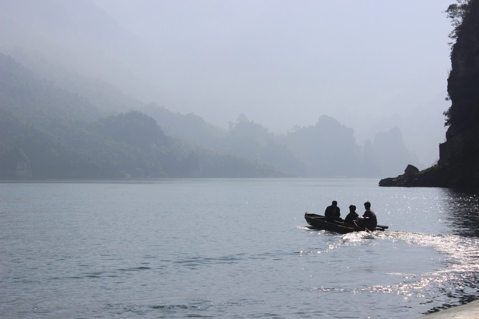 Con thuyền nhẹ nhàng trôi giữa lòng hồ thủy điện mênh mông sông nước. (Ảnh: Hùng Võ-Hoàng Chiên/Vietnam+)