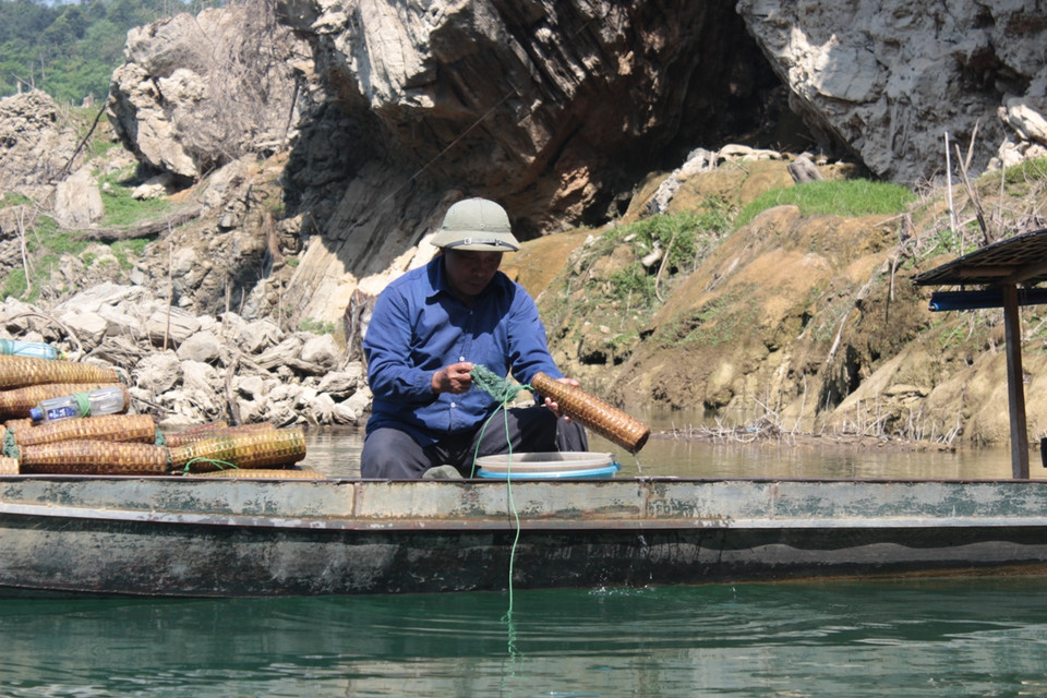 Người dân đổ tôm ven hồ thủy điện. (Ảnh: Hoàng Chiên-Hùng Võ/Vietnam+)