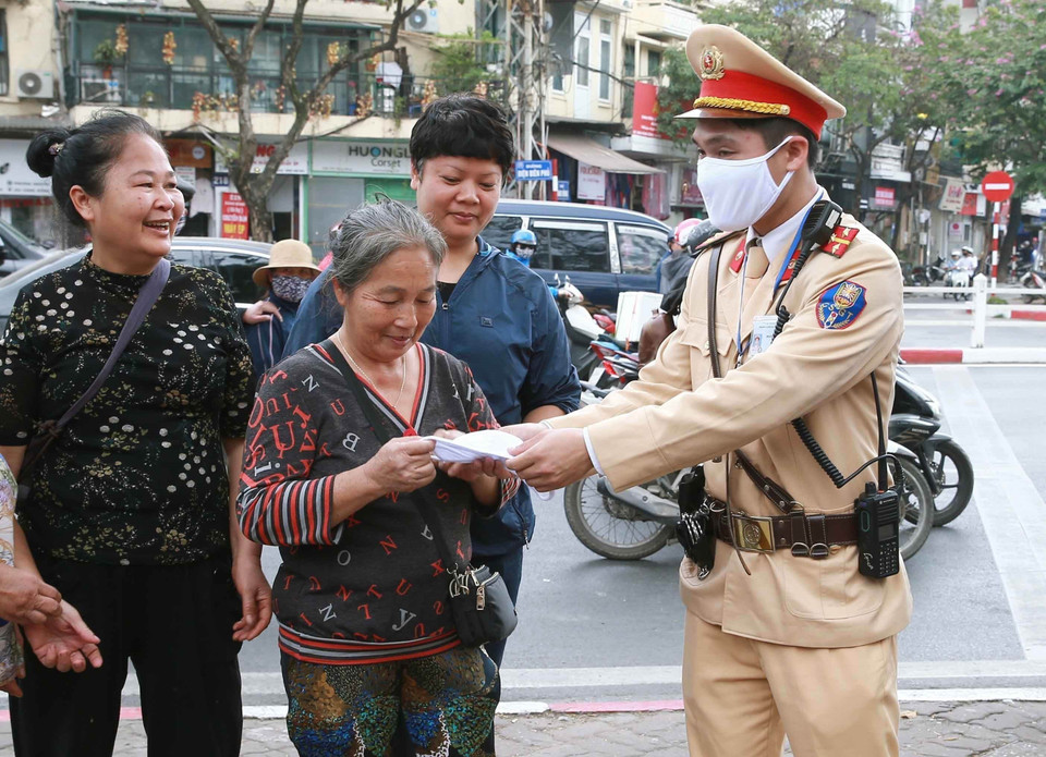 Cảnh sát giao thông Hà Nội tham gia phát khẩu trang phòng chống dịch COVID-19 cho người đi xe buýt (28/2/2020). (Ảnh: Doãn Tấn/TTXVN)