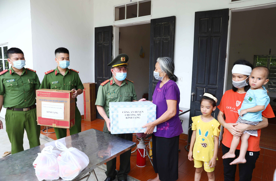 Công an huyện Chương Mỹ (Hà Nội) trao quà hỗ trợ gia đình anh Nguyễn Hữu Dương, hy sinh trong khi làm nhiệm vụ tại chốt phòng, chống dịch COVID-19. (Ảnh: Phạm Kiên/TTXVN)