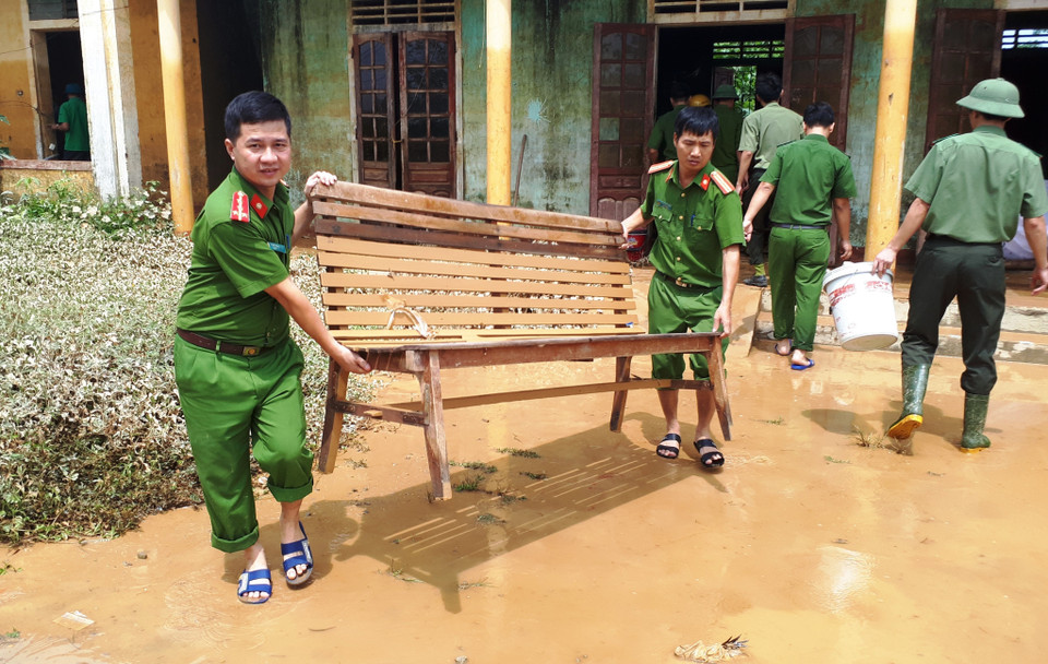 Các chiến sỹ công an huyện Hương Khê (Hà Tĩnh) chung tay dọn vệ sinh môi trường sau lũ tại xã Hương Đô. (Ảnh: Phan Quân/TTXVN)