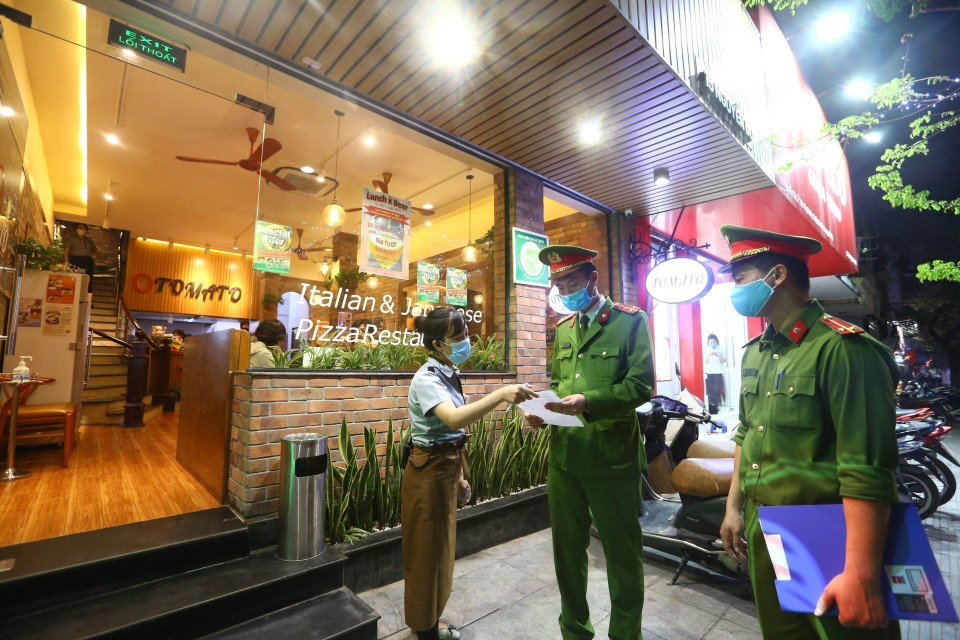 Công an phường Nguyễn Du (Hà Nội) tuyên truyền, nhắc nhở các cửa hàng đóng cửa theo quy định phòng chống dịch COVID-19 (26/3/2020). (Ảnh: Minh Quyết/TTXVN)