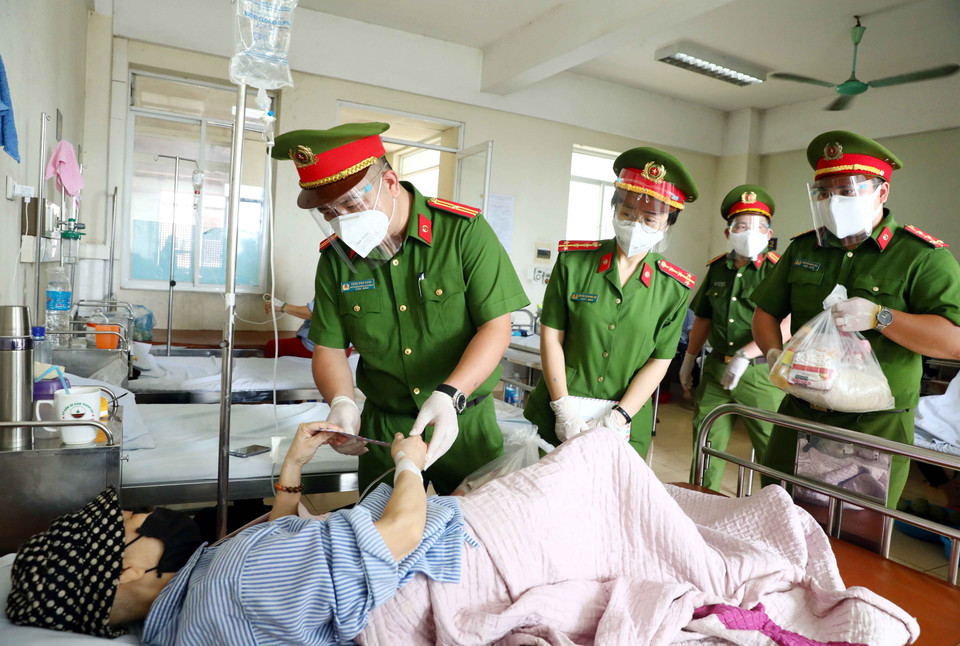 Cán bộ, chiến sỹ Công an phường Mai Dịch (quận Cầu Giấy, Hà Nội) trao quà hỗ trợ cho bệnh nhân có hoàn cảnh khó khăn đang điều trị tại trung tâm Ung Bướu, bệnh viện 19/8 Bộ Công an. (Ảnh: Phạm Kiên/TTXVN)