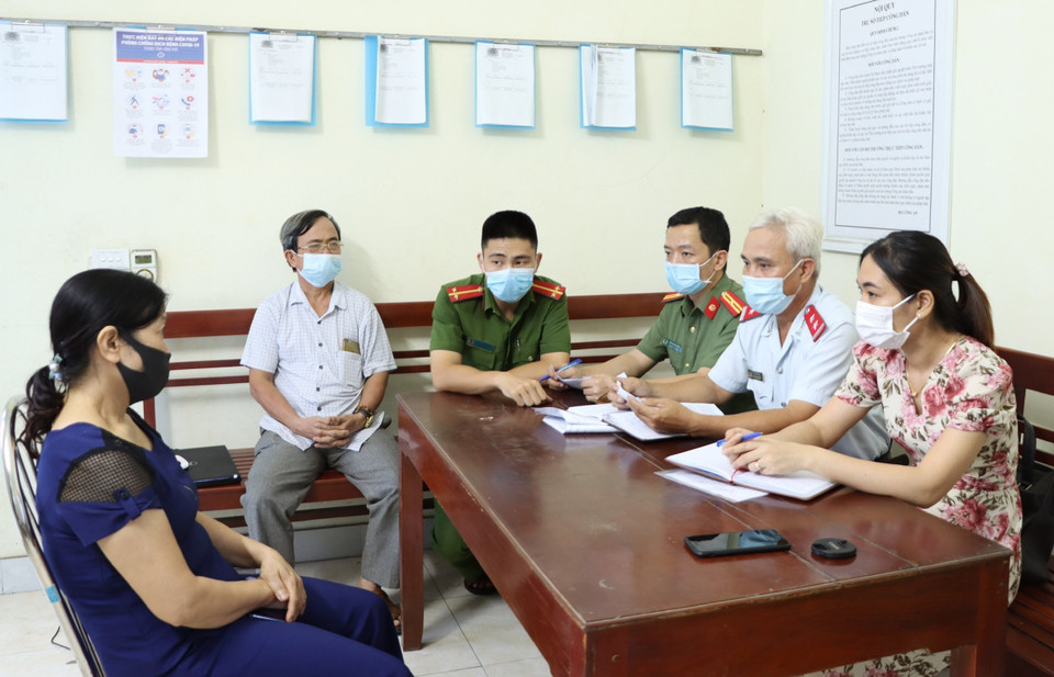 Đối tượng N.T.Tuyết (bên trái), sinh năm 1965, trú tại phường Yên Bình, thành phố Tam Điệp, tỉnh Ninh Bình tại buổi làm việc với cơ quan chức năng để làm rõ về hành vi cung cấp, chia sẻ thông tin bịa đặt trên mạng xã hội rằng “chân ngôn” Pháp Luân Công chữa khỏi bệnh COVID-19. Cơ quan chức năng đã ra quyết định xử phạt vi phạm hành chính đối tượng 10 triệu đồng và yêu cầu gỡ bỏ bài viết, cam kết không tái phạm. (Ảnh: Đức Phương/TTXVN)