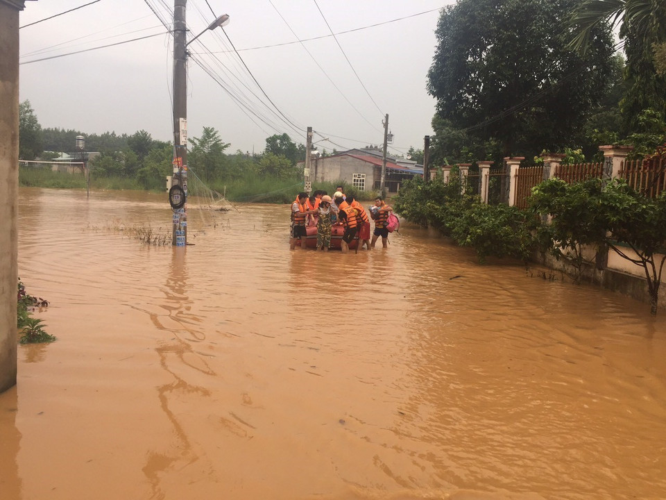  Giúp đỡ người dân di chuyển người và tài sản đến khu vực an toàn. (Ảnh: Đậu Tất Thành/TTXVN)