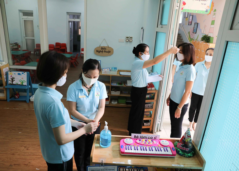 Giáo viên Mầm non Đại Kim, quận Hoàng Mai diễn tập phương án đón và chăm sóc ăn, ngủ cho trẻ, sẵn sàng đón trẻ vào ngày 11/5 tới. (Ảnh: Thanh Tùng/TTXVN)