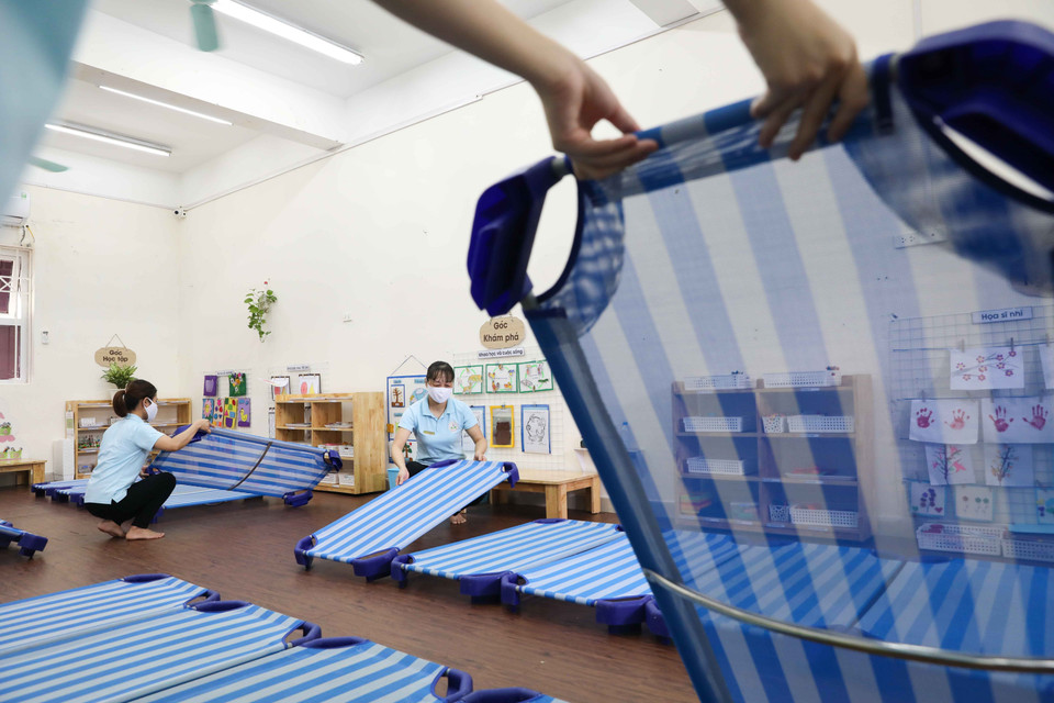 Giáo viên Mầm non Đại Kim, quận Hoàng Mai diễn tập phương án đón và chăm sóc ăn, ngủ cho trẻ, sẵn sàng đón trẻ vào ngày 11/5 tới. (Ảnh: Thanh Tùng/TTXVN)