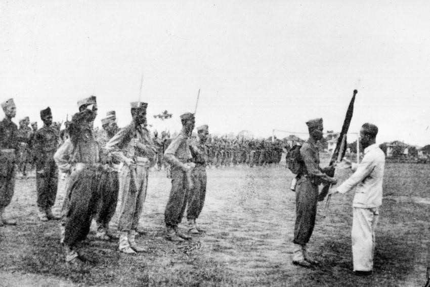 Chủ tịch Hồ Chí Minh trao tặng lá cờ thêu dòng chữ 'Trung với nước, hiếu với dân' cho các học viên khóa I của Trường Lục quân Trần Quốc Tuấn (22/4/1946). (Ảnh: TTXVN)